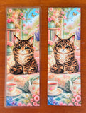 Cute cat bookmark with fluffy chibi cat, floral reading nook, tea set, flowers, and matte or laminated finish options.
