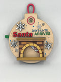 Close up of handmade basswood Christmas countdown ornament with Santa design
